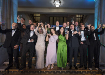 The winners with their trophies celebrate on the podium