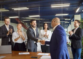 Corporate executives celebrate a deal with a handshake and applause. Picture for illustrative purposes only.