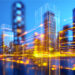 Digital cityscape with illuminated buildings and flowing light trails, representing structured infrastructure and scalable systems supporting growth.
